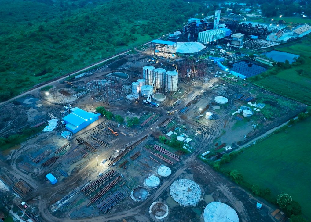 The distillery site at dusk, storage tanks lit from below