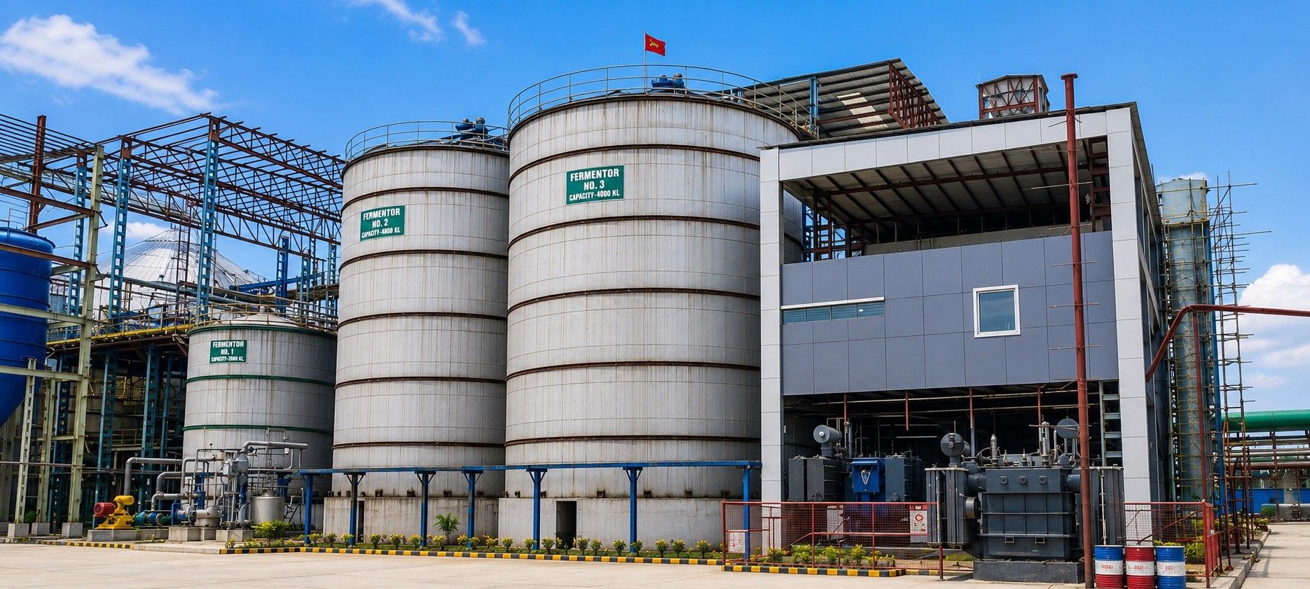 The fermentor hall at the grain distillery: three fermentation vessels beside the process building