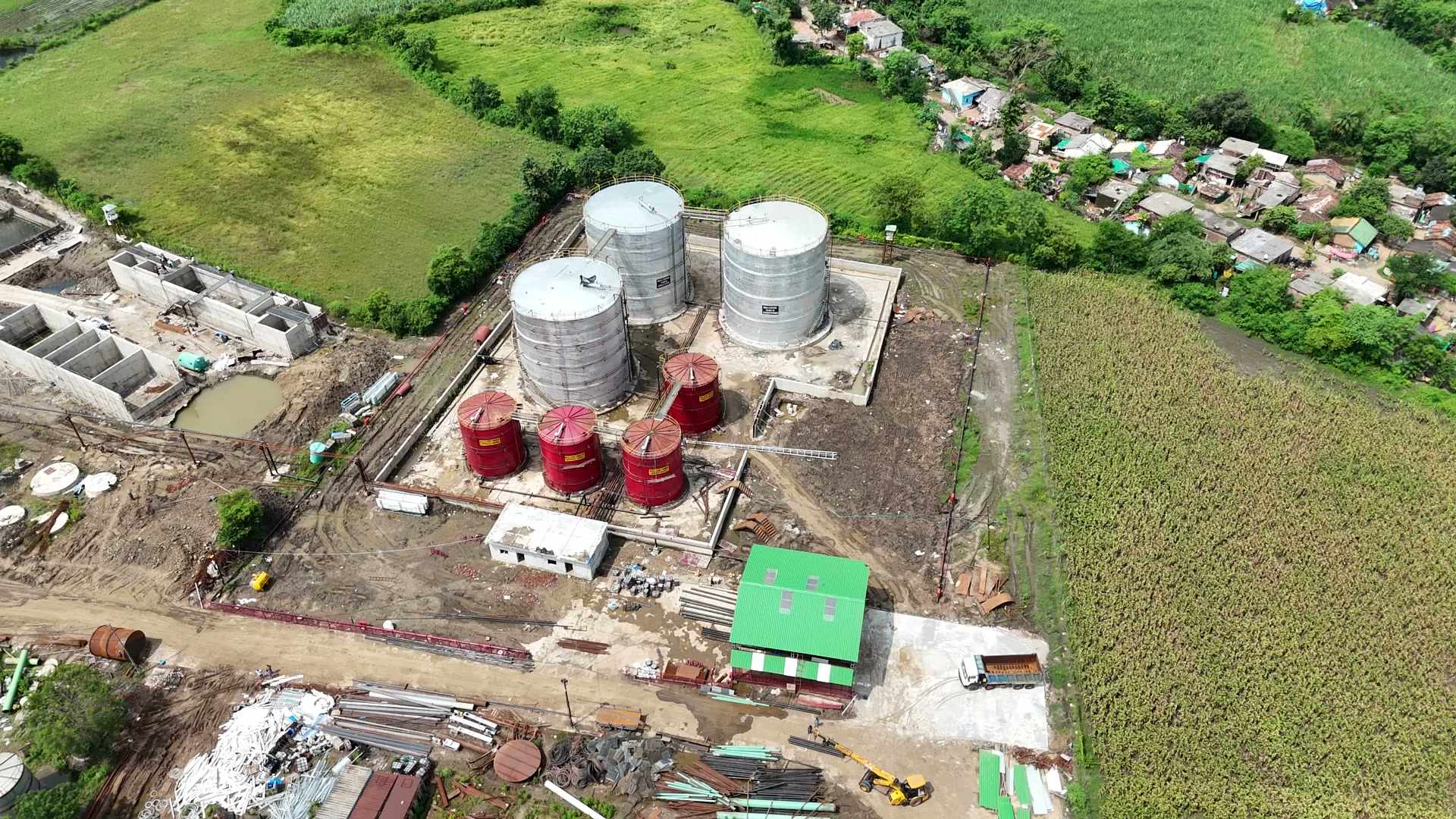 Aerial photograph of the Mahakaushal site at Bachai: the storage tanks and plant buildings, with the fields and the village around them.