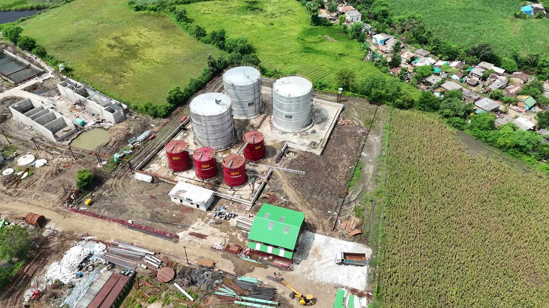 Aerial view of the Bachai complex — the mill, the distillery and the chimneys — with cane fields beyond