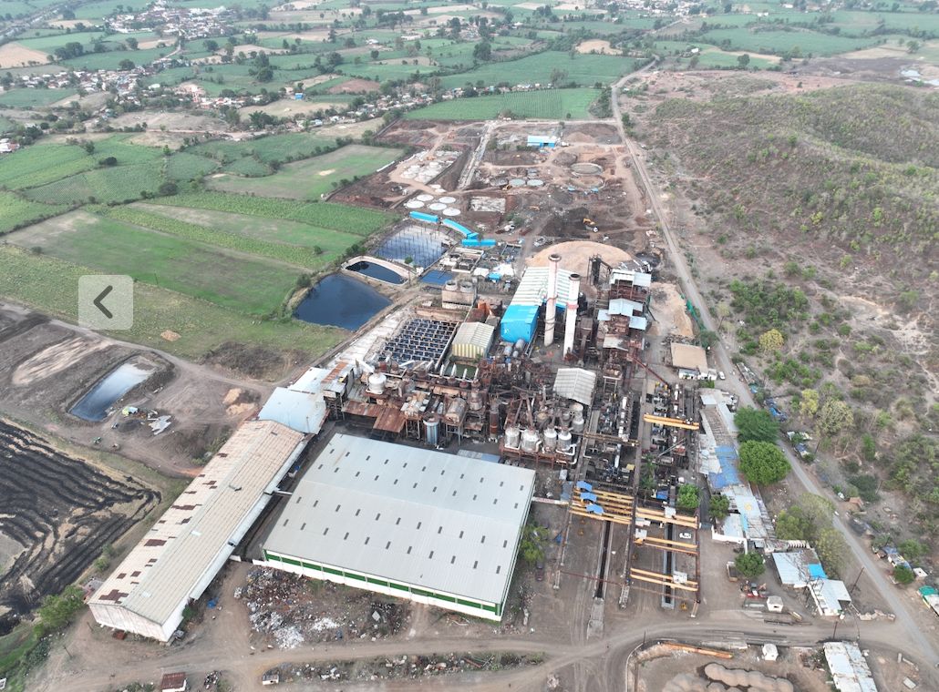 Aerial view of the sugar mill at Bachai, white roofs among green fields